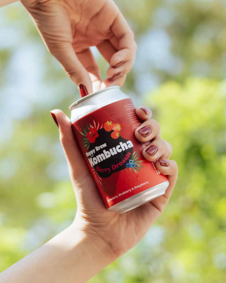 Hand opening a can of Happy Brew Kombucha Berry Dreams in Manila, Philippines β refreshing probiotic drink with strawberry, blueberry, and raspberry juice