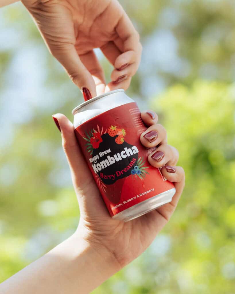 Hand opening a can of Happy Brew Kombucha Berry Dreams in Manila, Philippines – refreshing probiotic drink with strawberry, blueberry, and raspberry juice